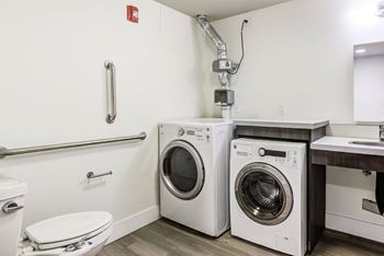 a washer and dryer in a bathroom with a toilet and sink